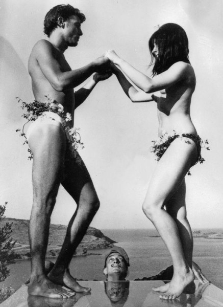 Salvador Dali looking at his models standing on thick glass plate posing for new painting of Sardana